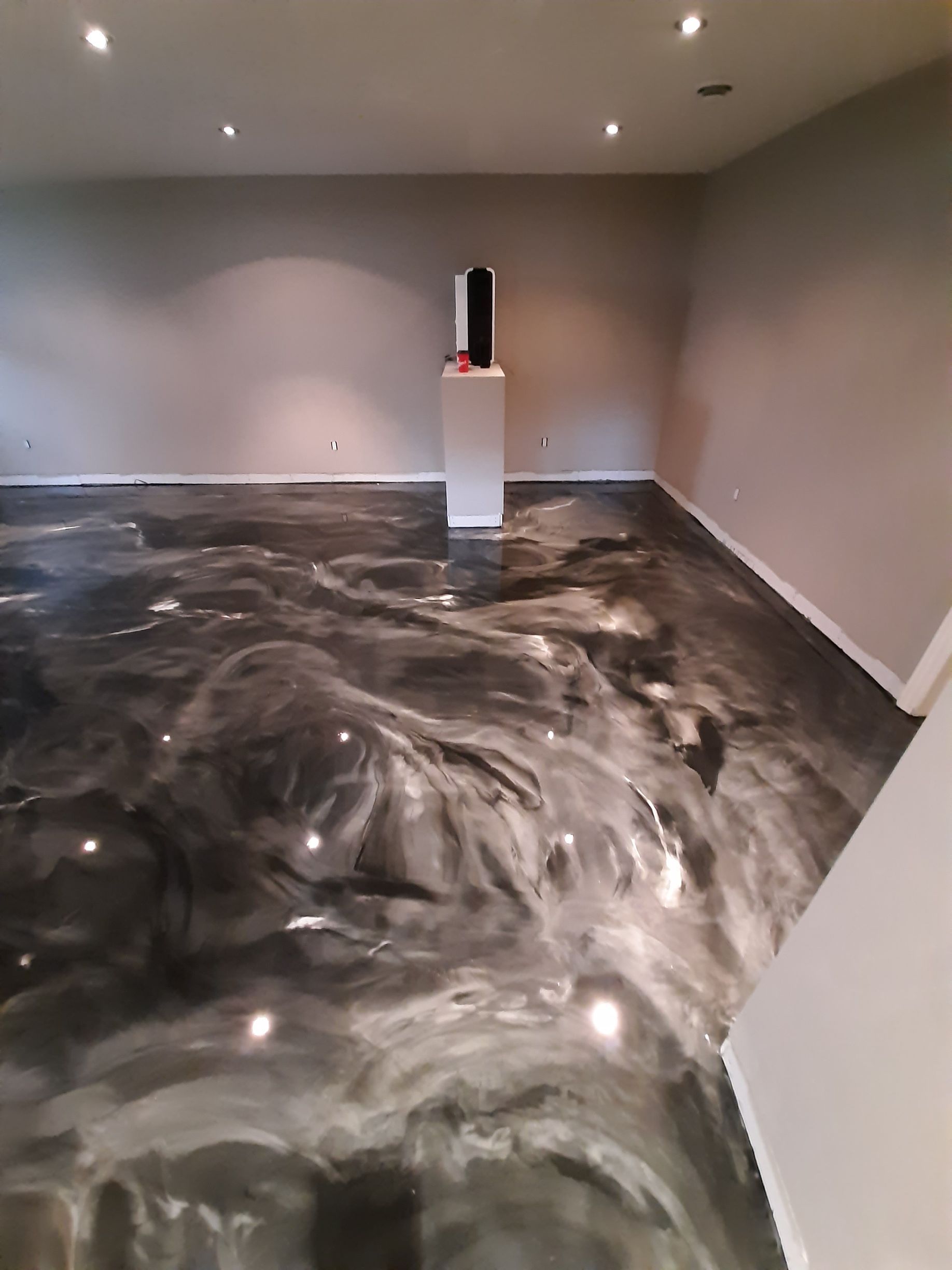 Une pièce avec un sol métallique et une statue sur un piédestal.