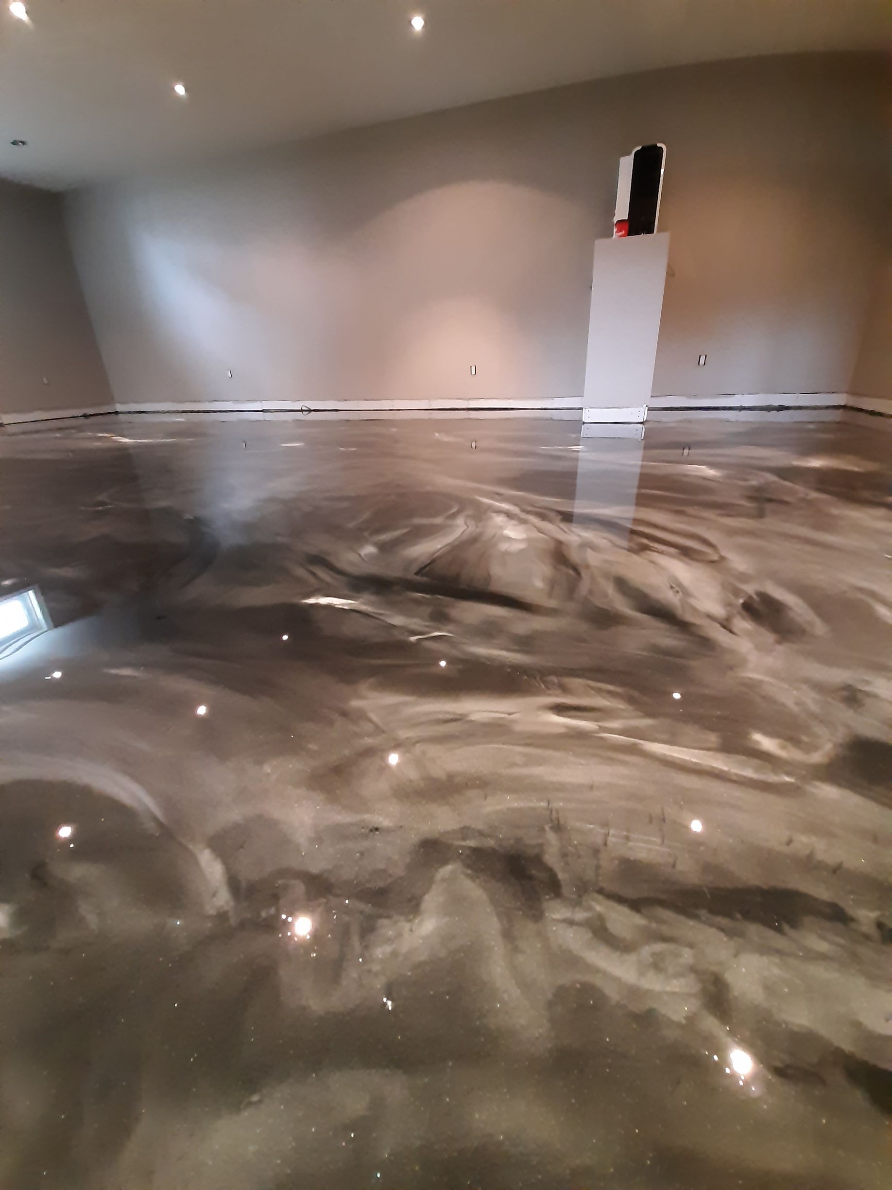 Un sol métallique brillant dans un sous-sol avec un reflet de lumières.