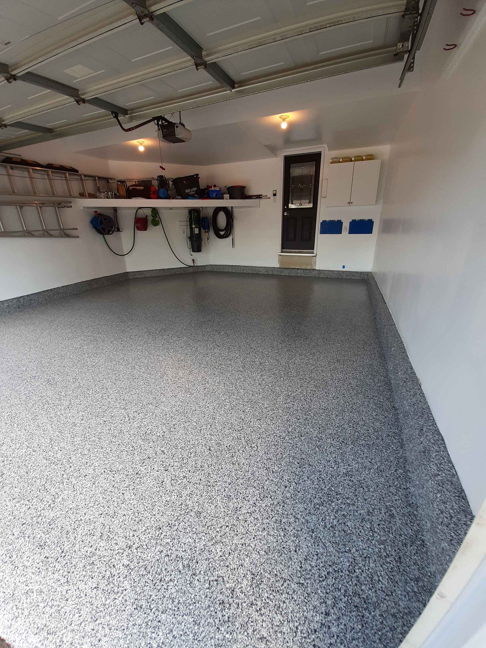 Un garage avec un sol gris et des murs blancs