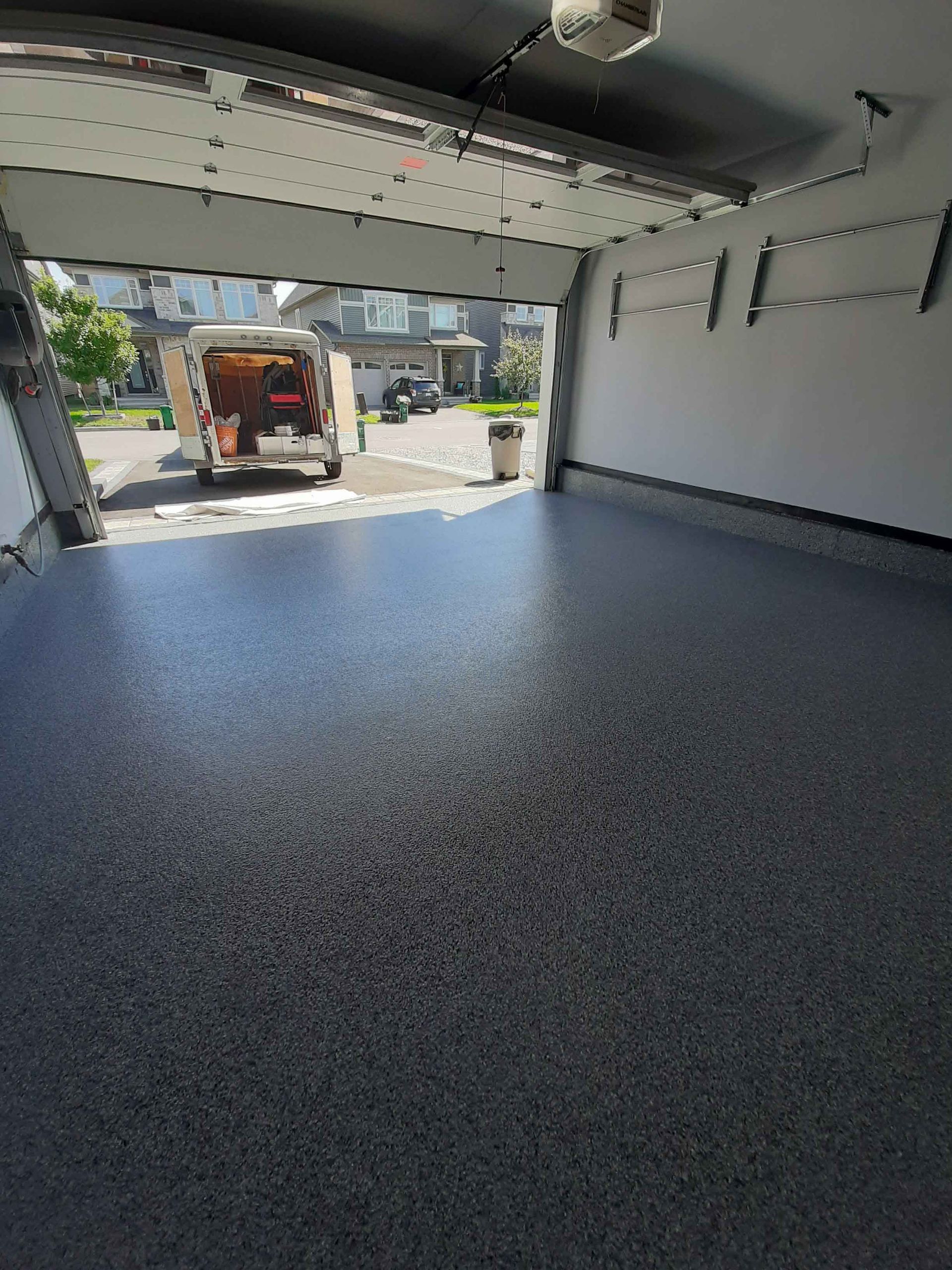 Une camionnette est garée dans un garage avec la porte ouverte.