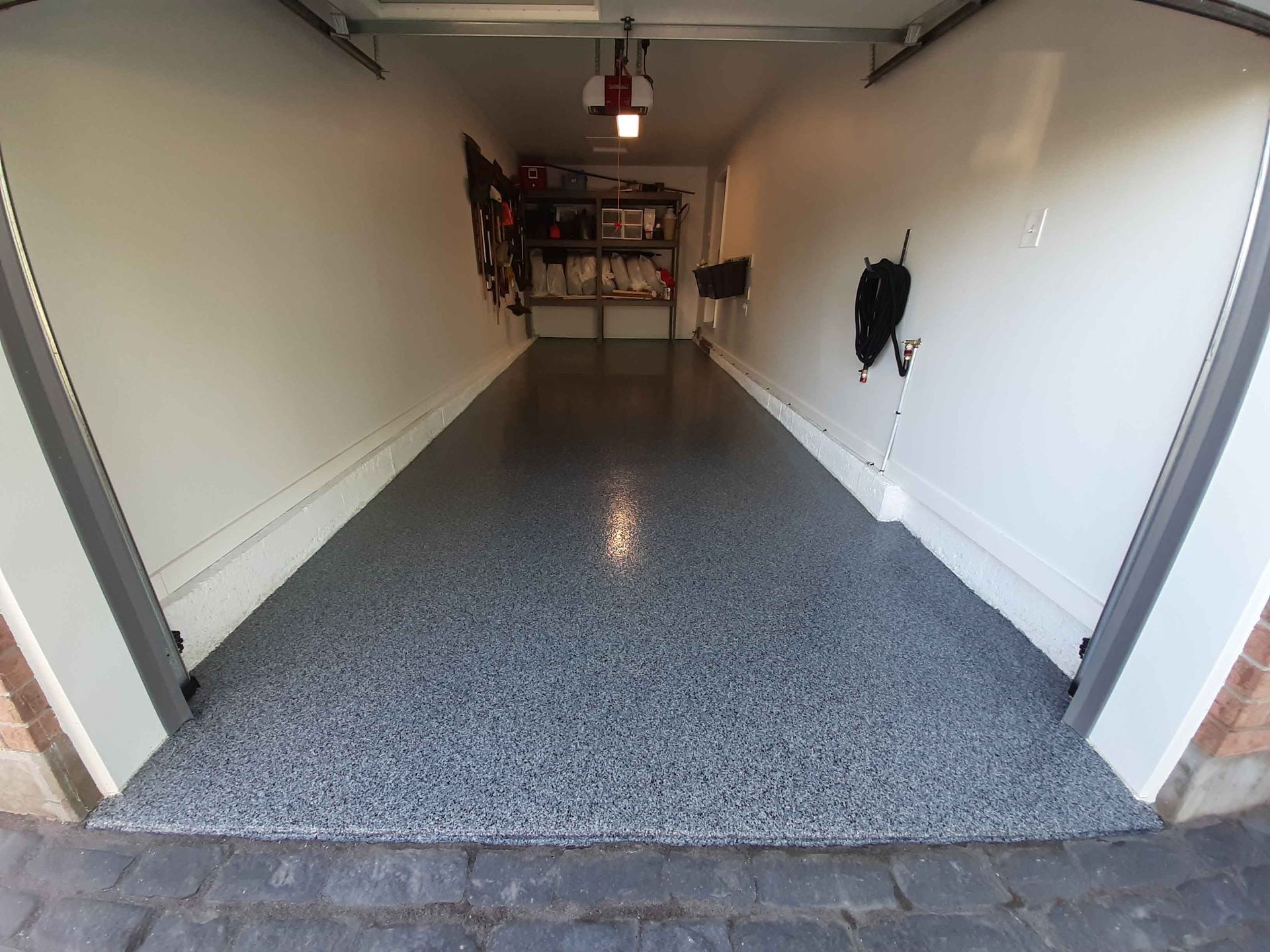 Un garage avec un sol gris et des murs blancs