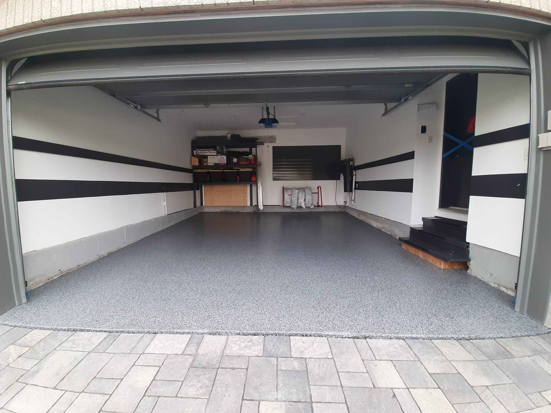 Un garage avec la porte ouverte et un sol en briques