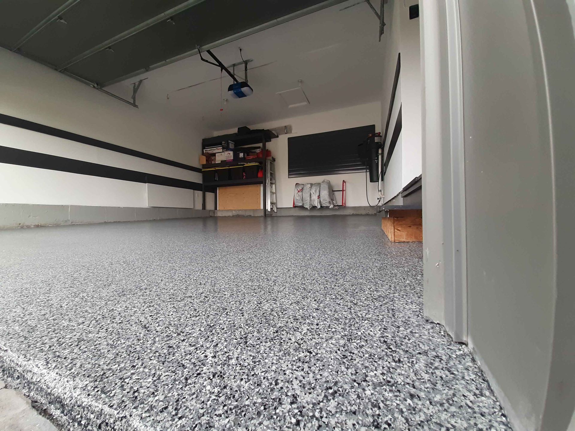 Un garage avec un sol gris et un mur noir et blanc.