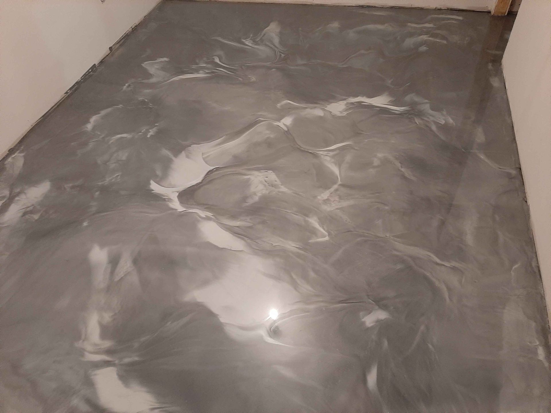 Un sol en marbre gris et blanc dans une pièce.