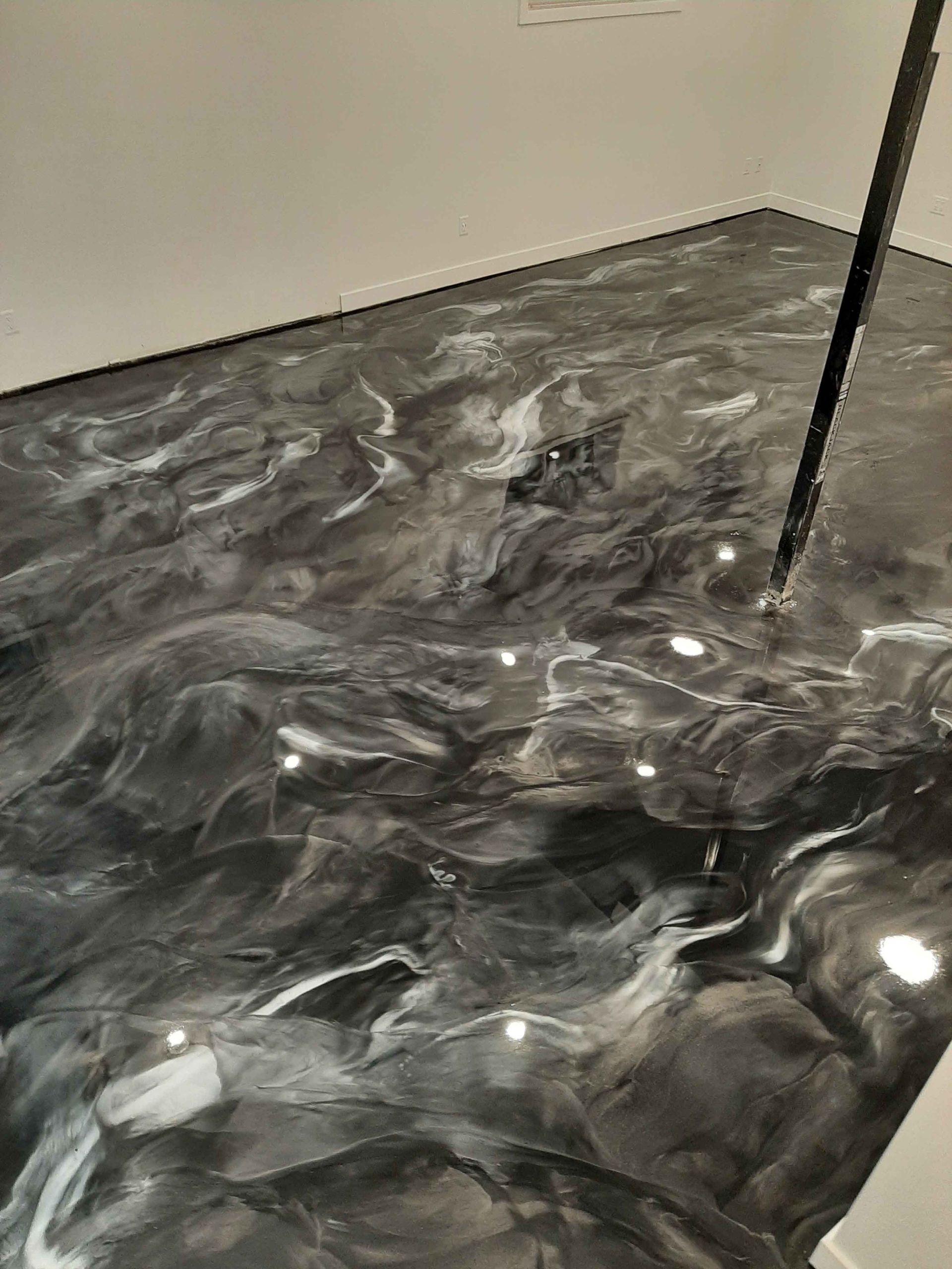 Un gros plan d'un sol métallique noir et blanc dans une pièce.