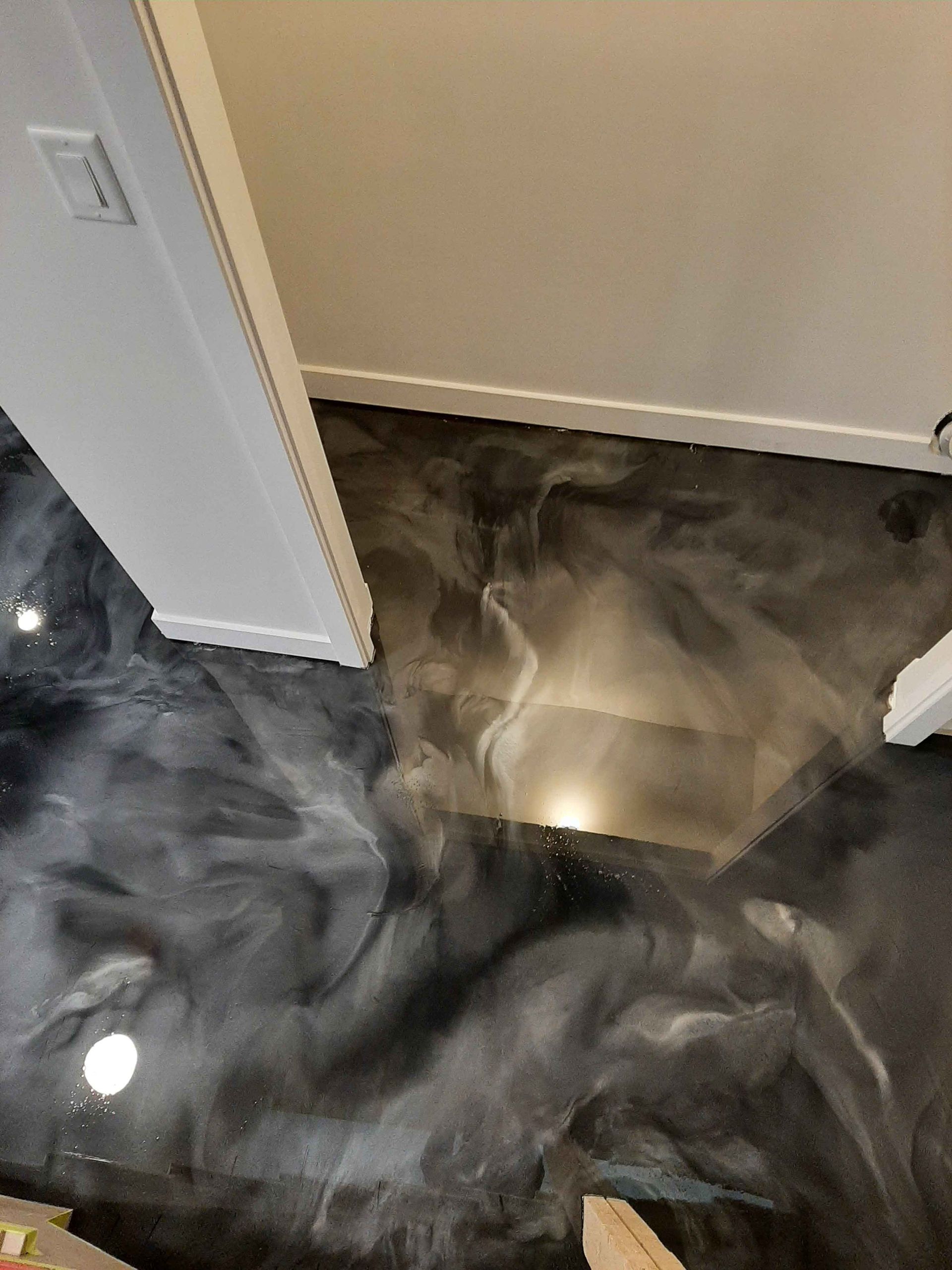 Un sol métallique noir et argent dans un couloir.