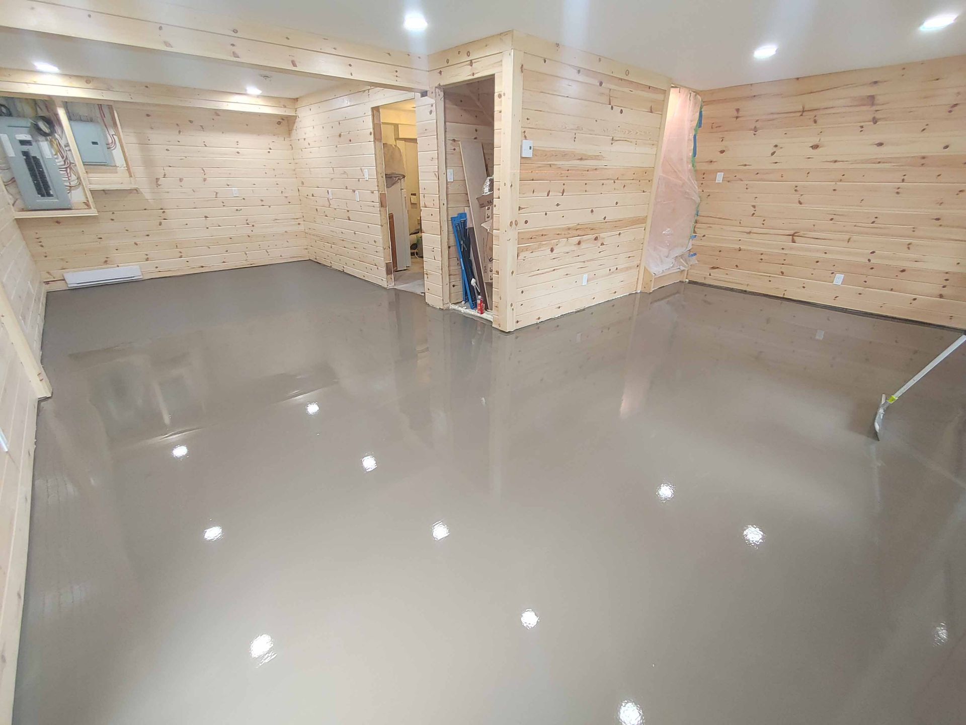 A basement with a concrete floor and wooden walls.