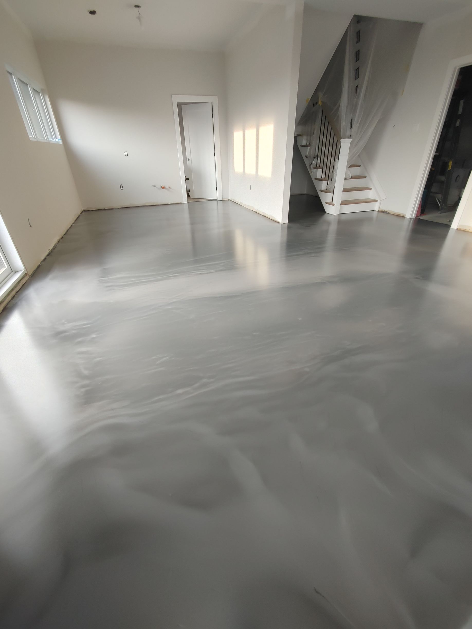 Un salon avec un sol et des escaliers métalliques brillants.