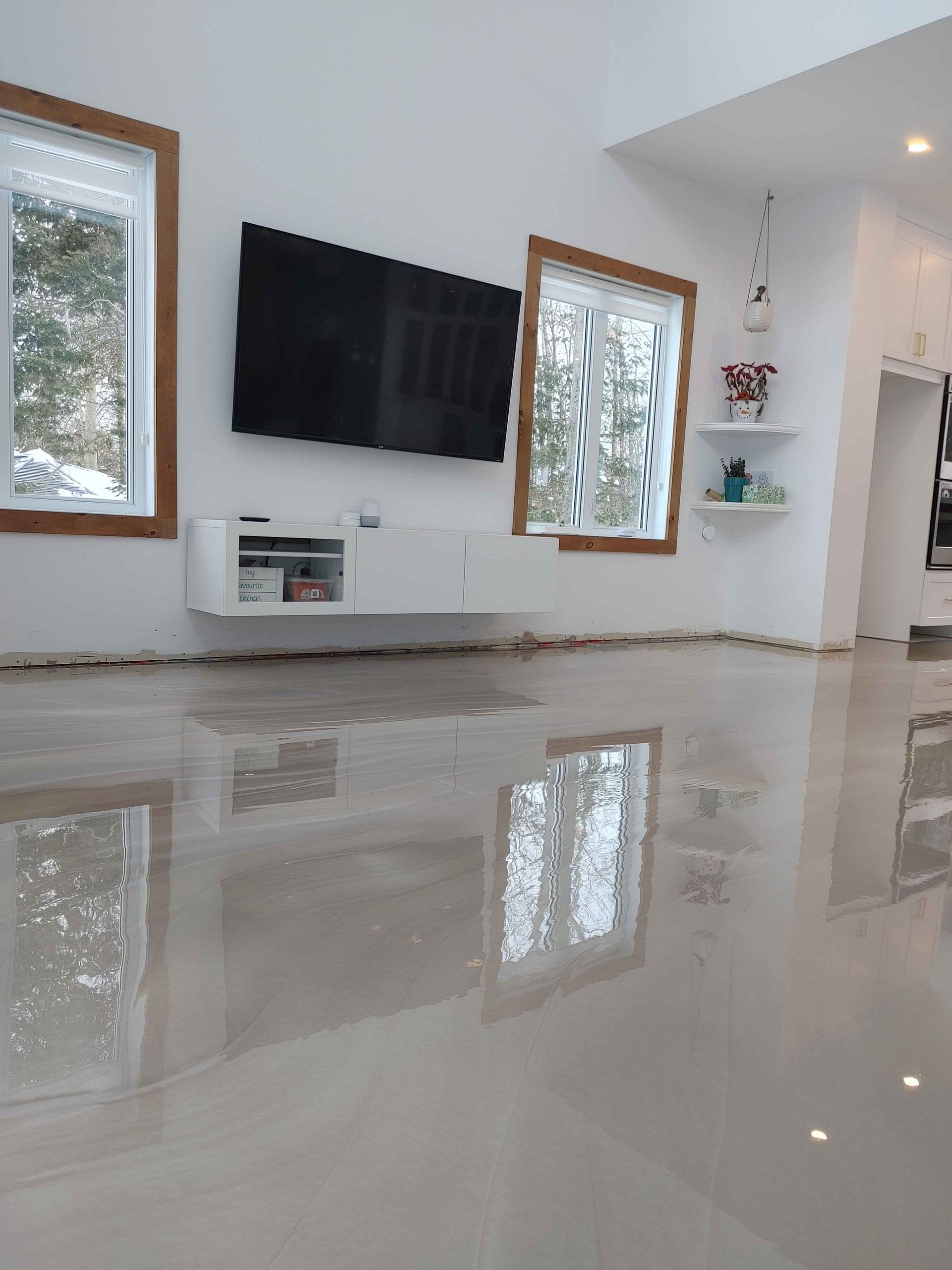 Un salon avec une télévision à écran plat fixée au mur.