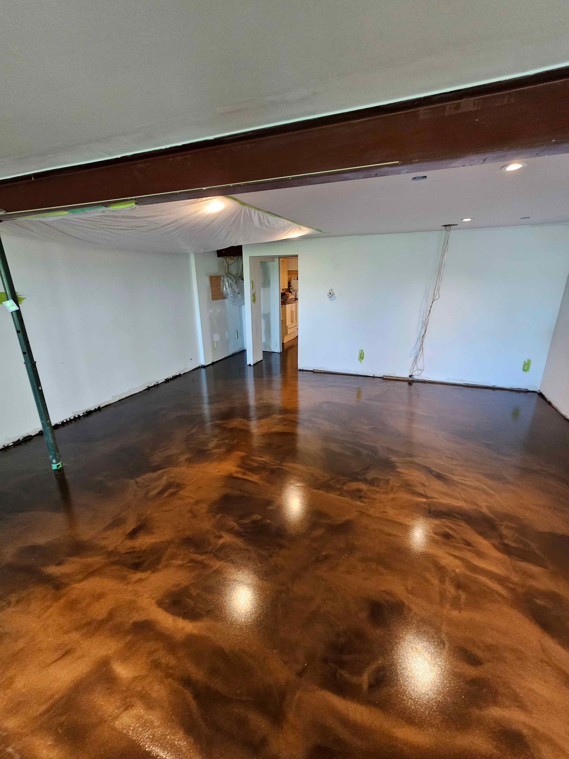 Un salon avec un sol métallique marron et des murs blancs.