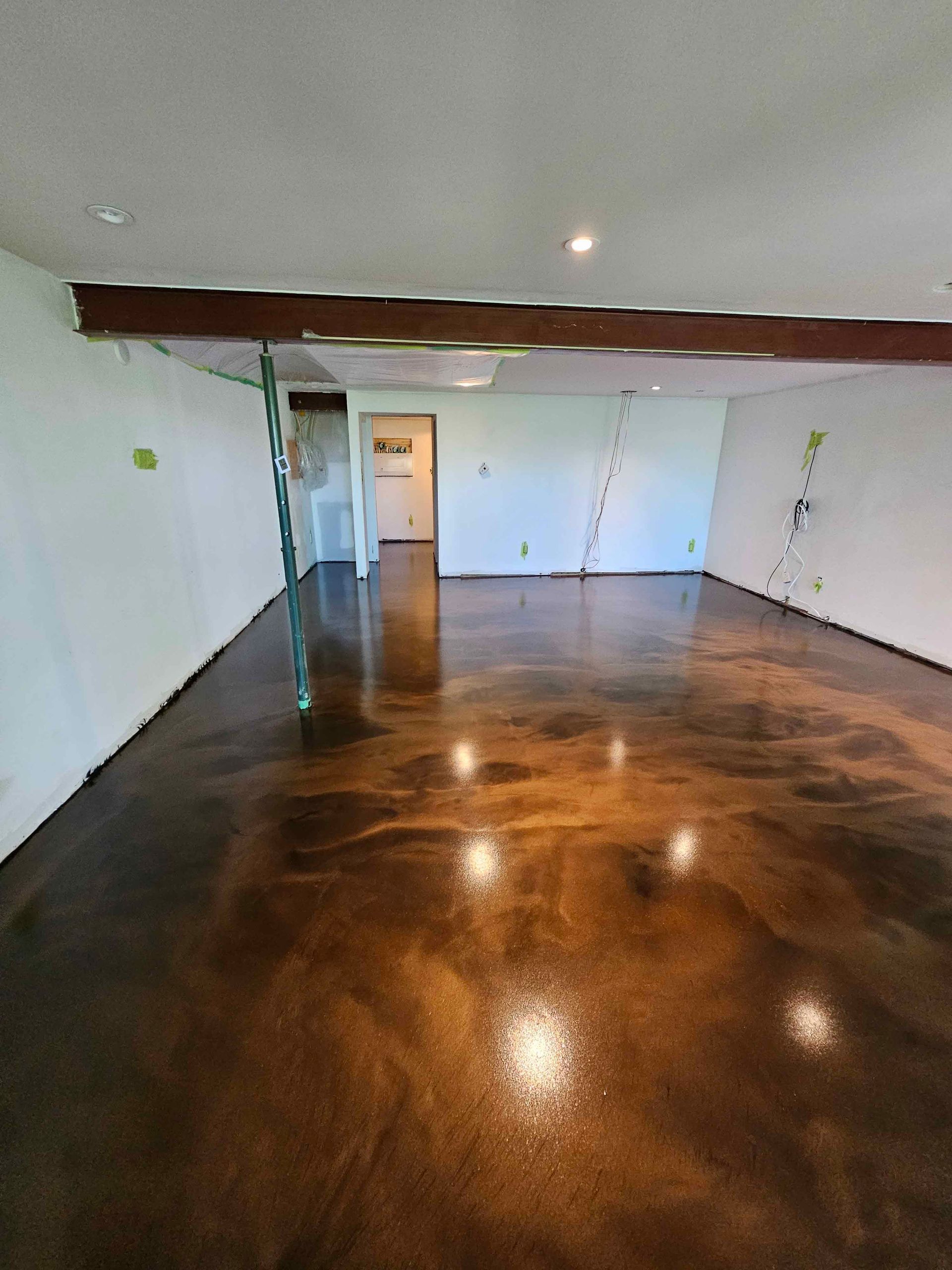 A large room with a shiny concrete floor and white walls.