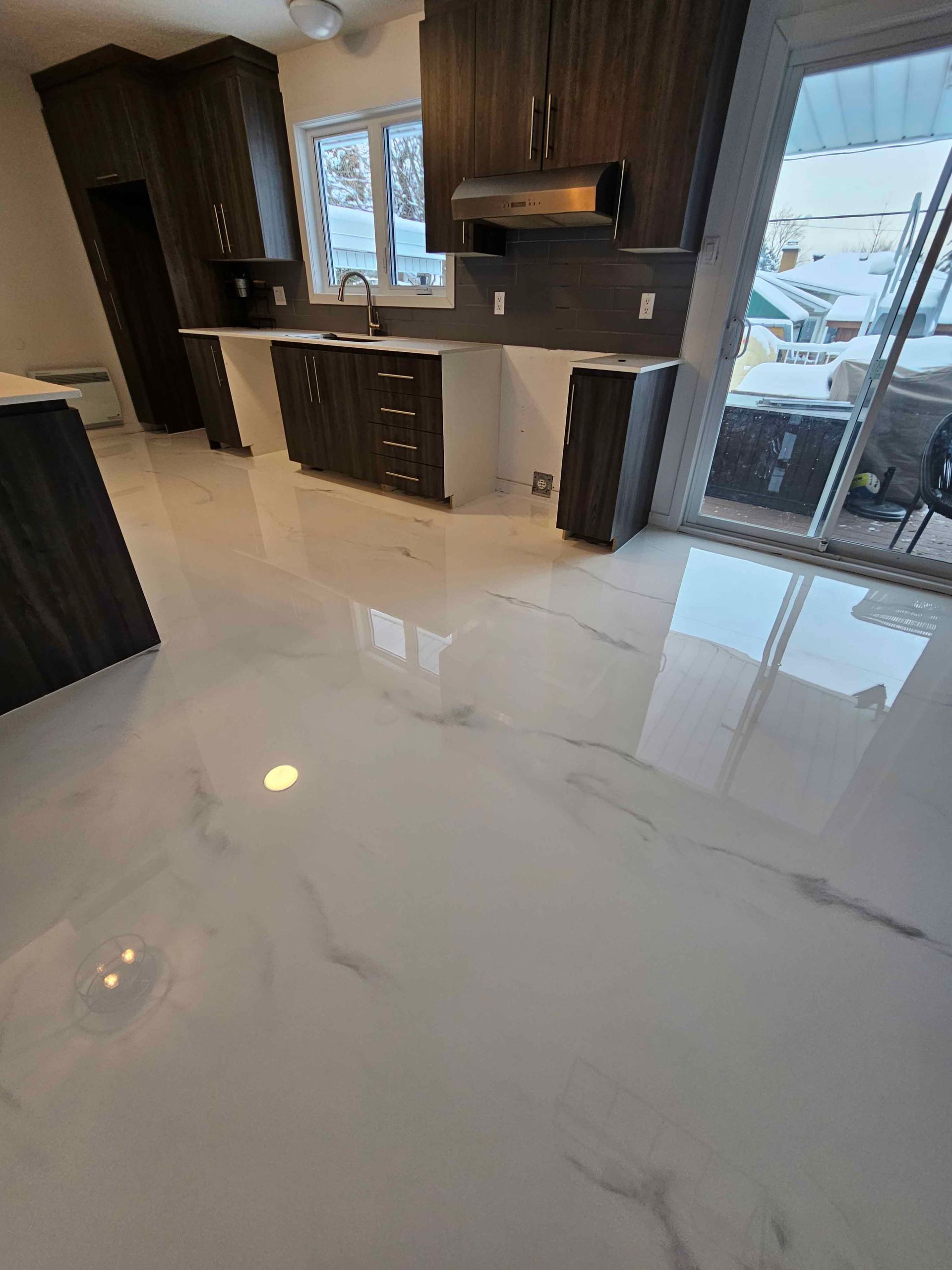 Une cuisine avec un sol en marbre et des armoires en bois.