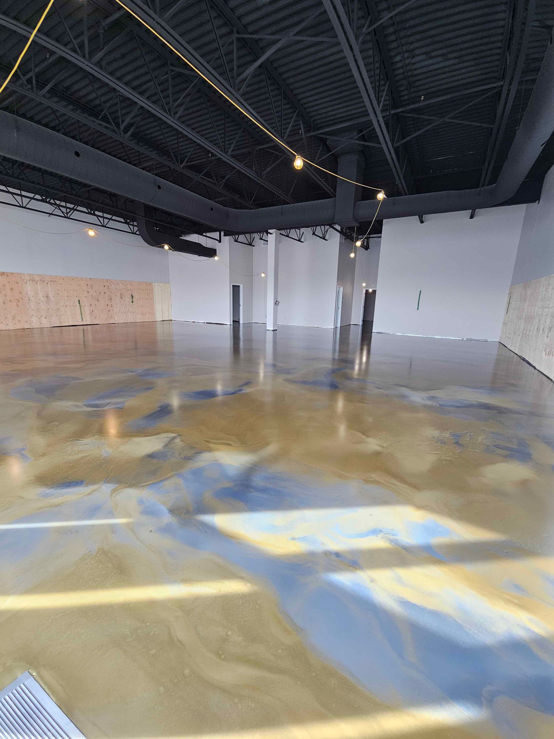 Une grande pièce vide avec un sol et un plafond en béton.