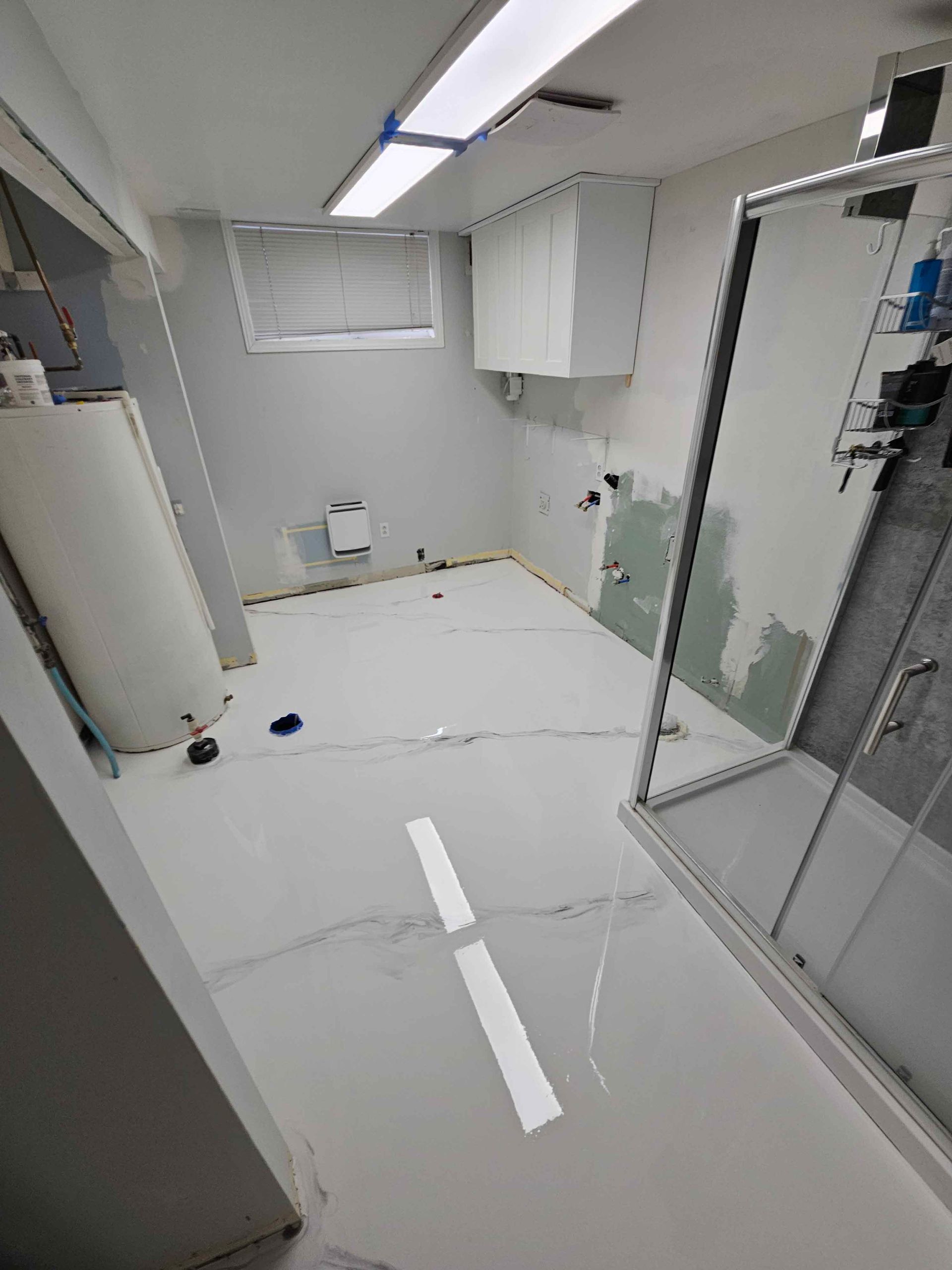 Une salle de bain avec carrelage blanc et une cabine de douche.