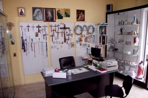 Una scrivania in una stanza con tante croci sul muro