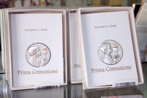 Due scatole di cartoline della prima comunione sono appoggiate su un tavolo.