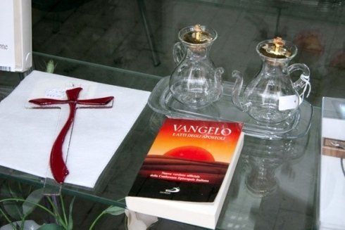 Un libro intitolato vangelo è appoggiato su un tavolo di vetro