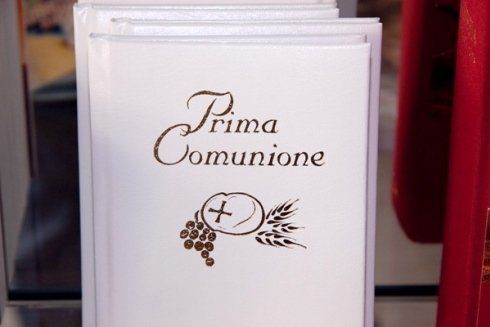 Un libro intitolato prima comunione è appoggiato su un tavolo.
