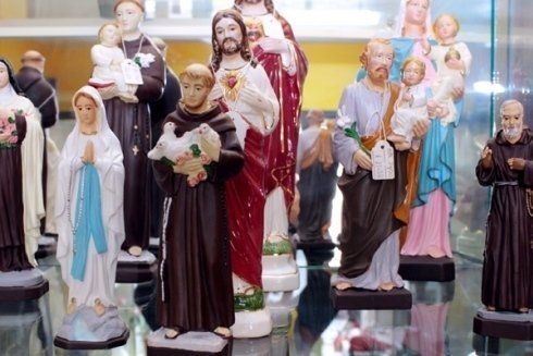 Un gruppo di statue di figure religiose sono su una mensola di vetro