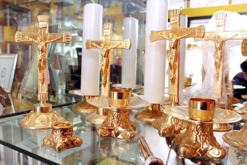 Una mostra di candele e croci su una mensola di vetro