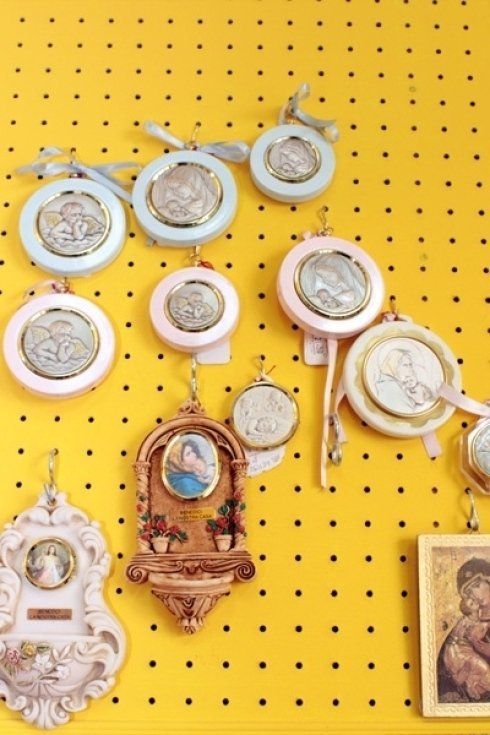 Un mucchio di oggetti religiosi sono appesi su una parete gialla