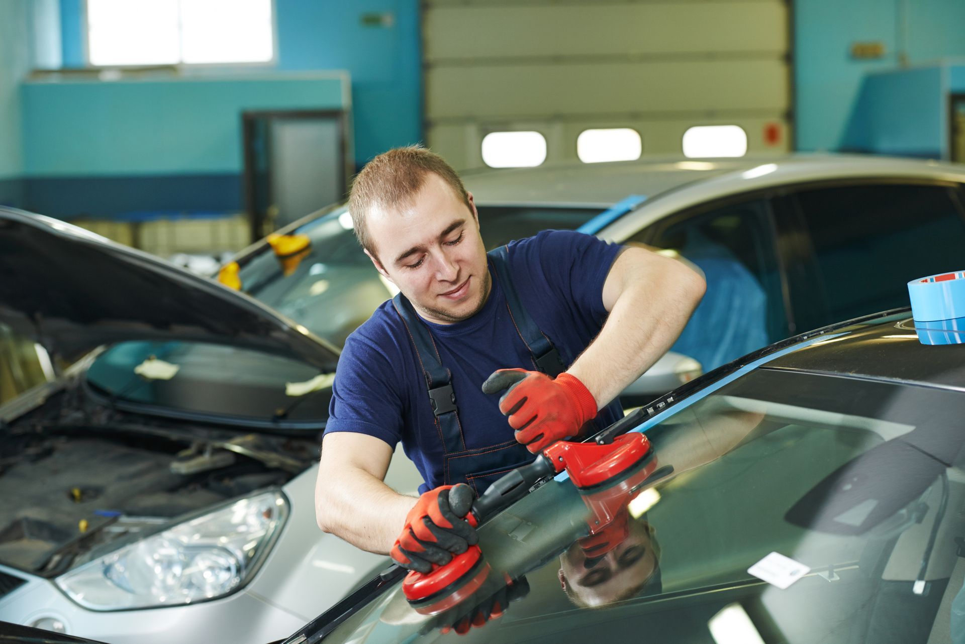 A mechanic is performing a car window replacement on a vehicle to restore functionality.