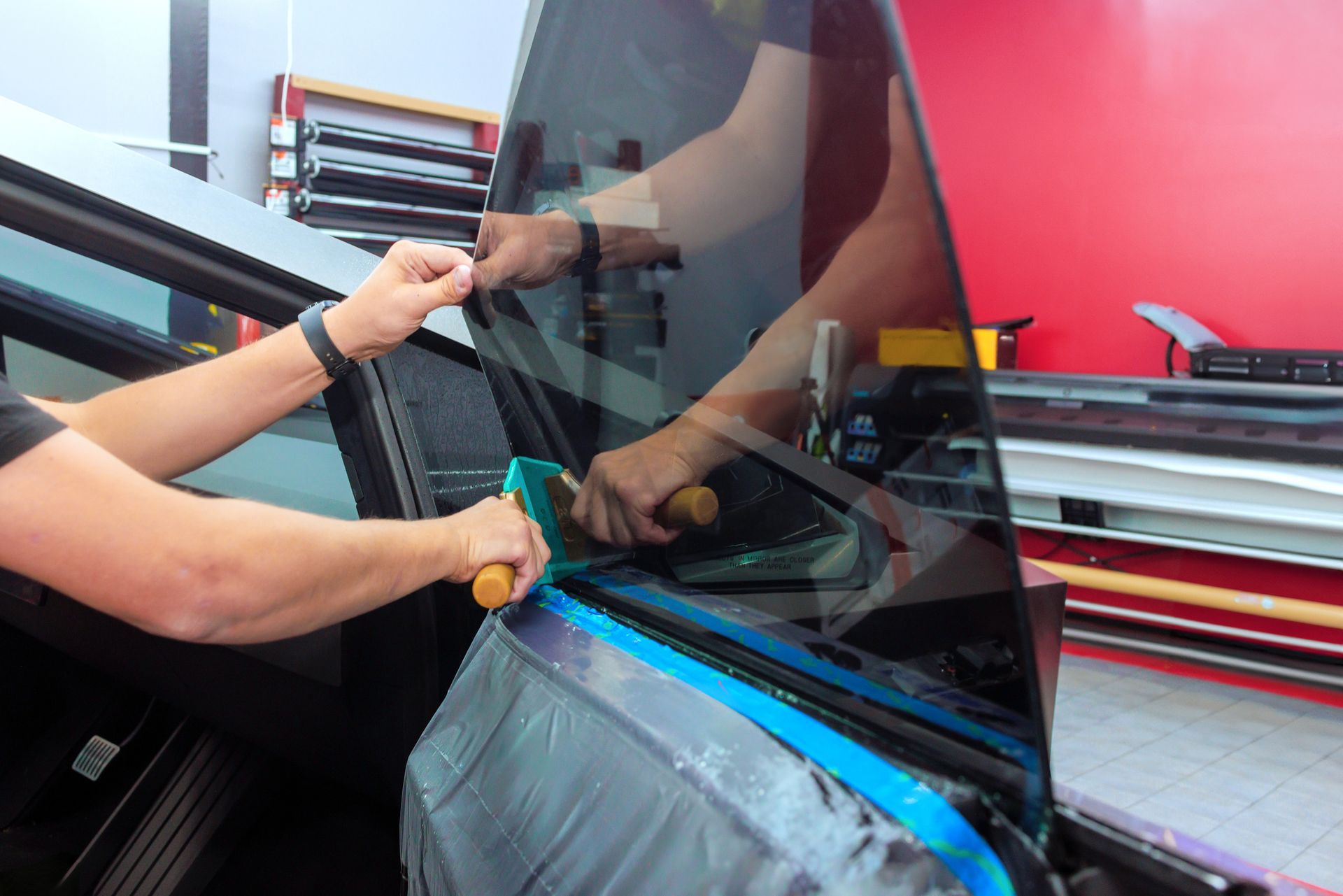 Auto glass technician completing car window replacement.