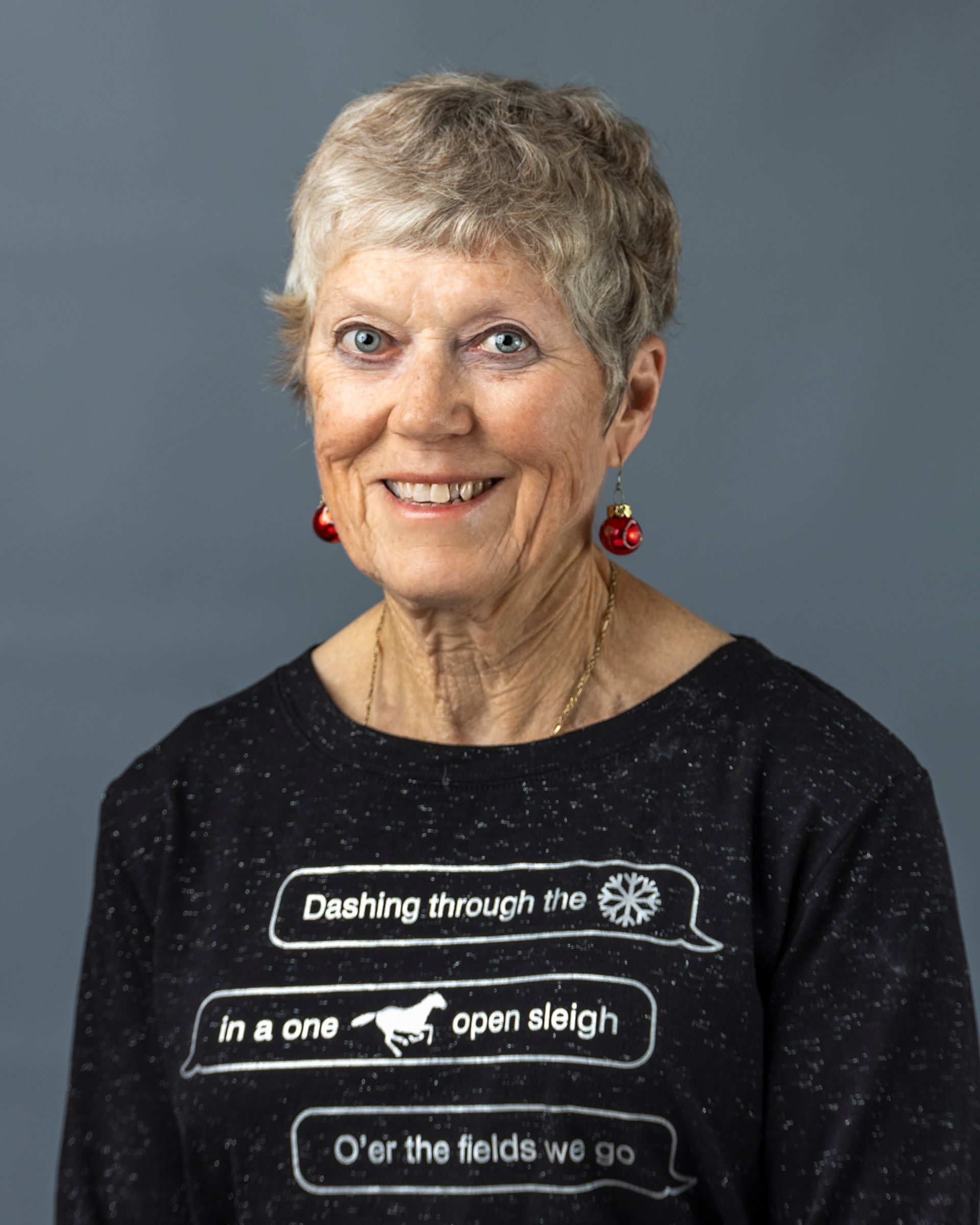 a woman wearing a sweater that says ' in a one open sleigh ' on it
