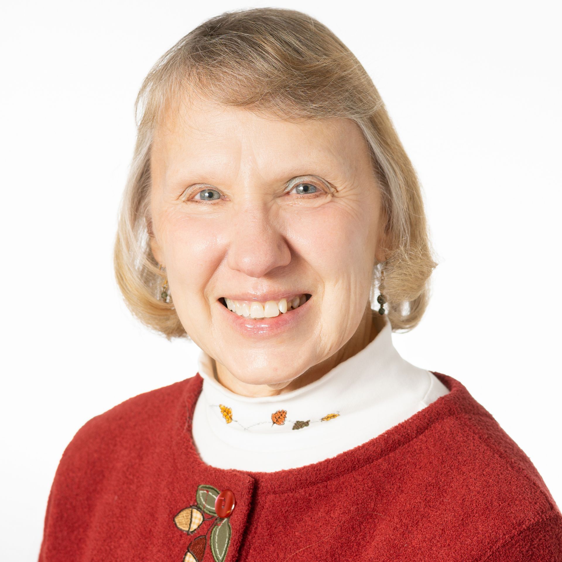 a woman in a red sweater is smiling for the camera