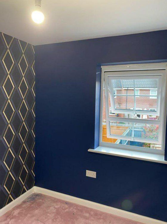 Picture of a kids bedroom with dark blue painted walls and feature wallpaper on  one wall carried out by painters and decorators Glasgow