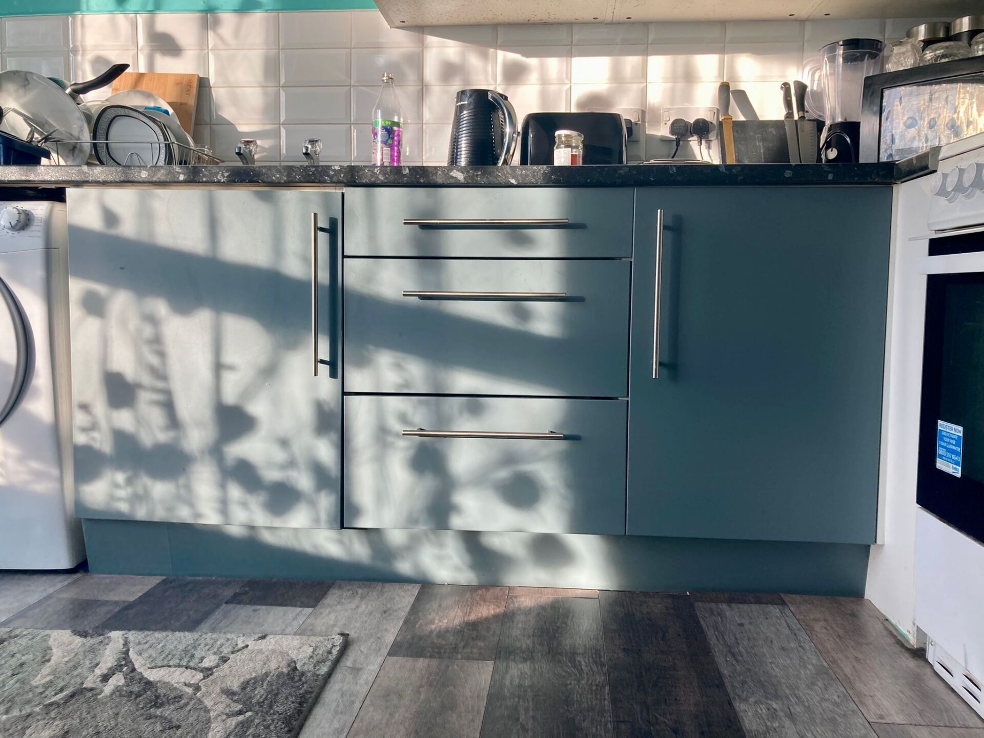Kitchen units wrapped in matt sage green by painters and decorators Glasgow
