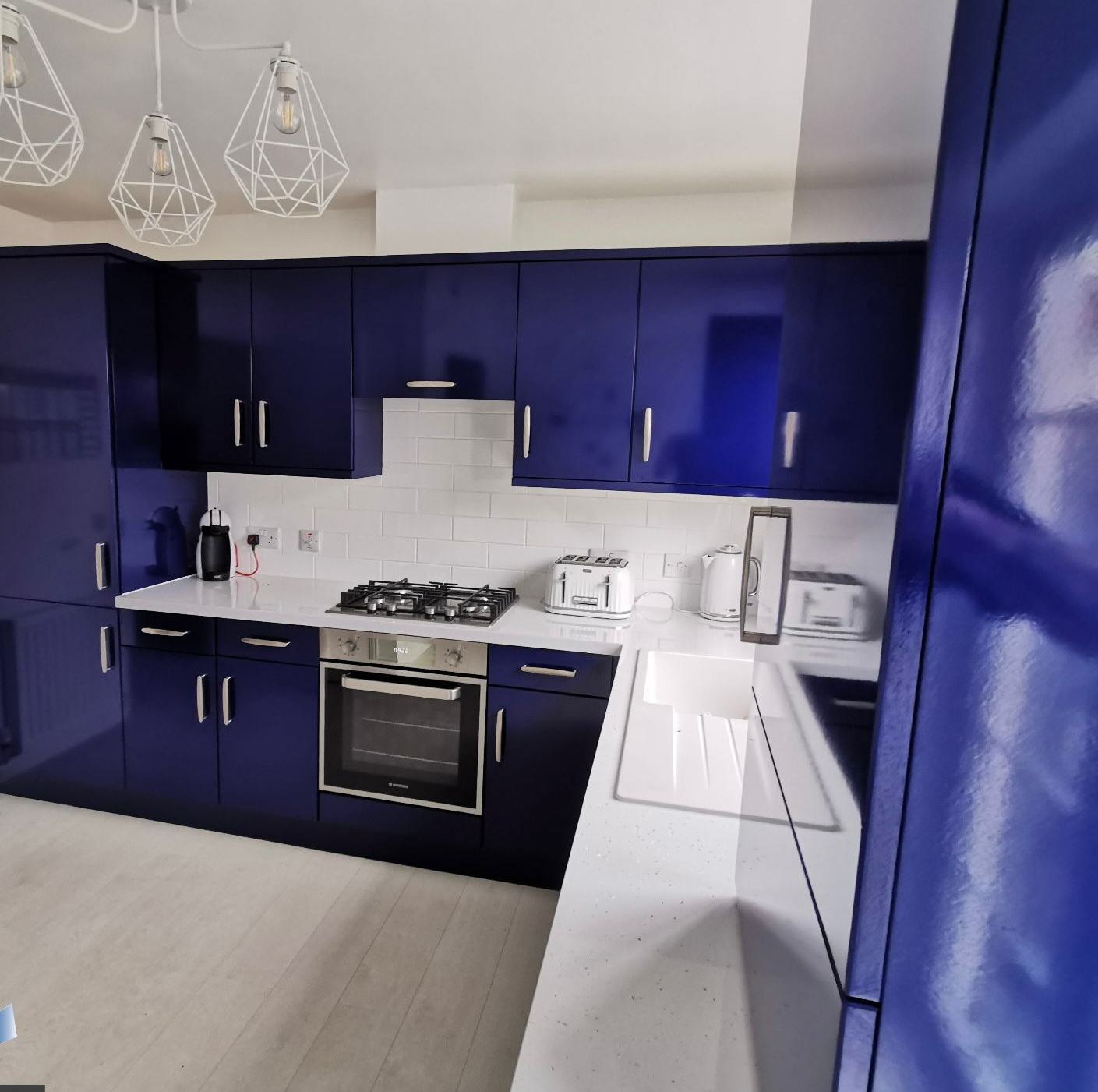 Kitchen units wrapped in high gloss midnight blue vinyl laminate by painters and decorators Glasgow