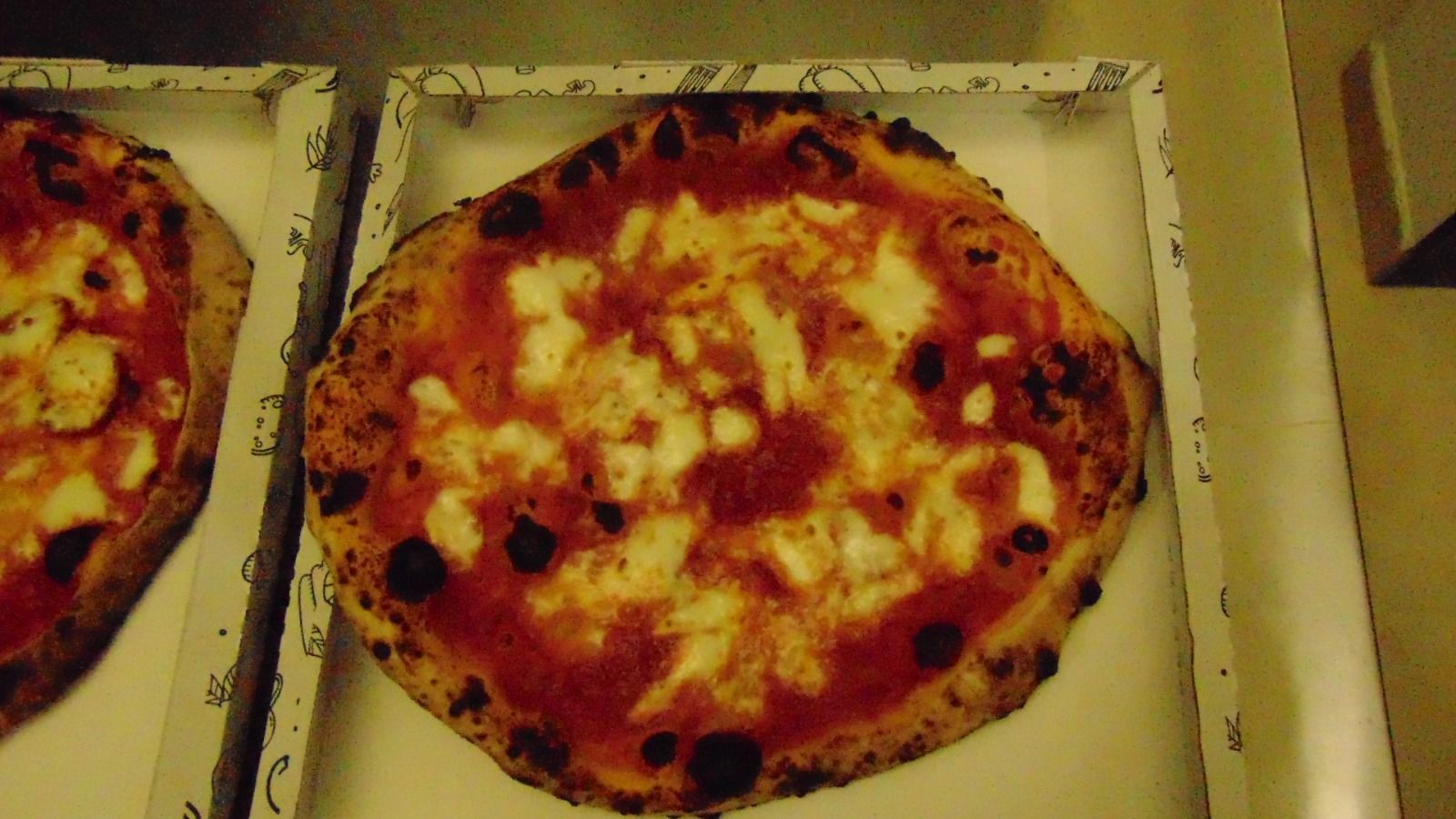 Pizza con salsa rossa e formaggio bianco in una scatola bianca.