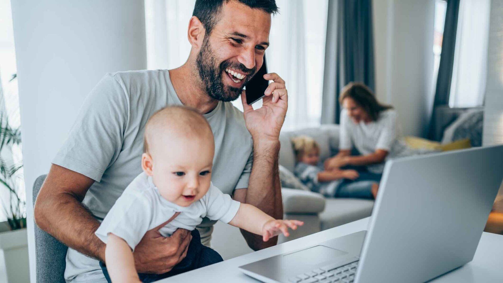 A Man On A Call Holding His Child — United States — NextGen Financial Advice