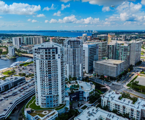 Aerial view of modern waterfront condos and marina under a blue sky