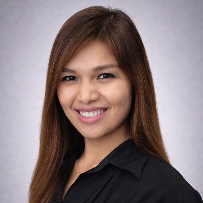 Smiling woman in a black shirt set against a solid orange circular background with a teal border.