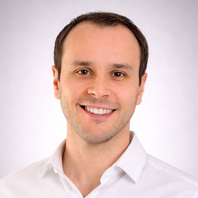 A smiling person centered in a circular frame with an orange background and a teal border.