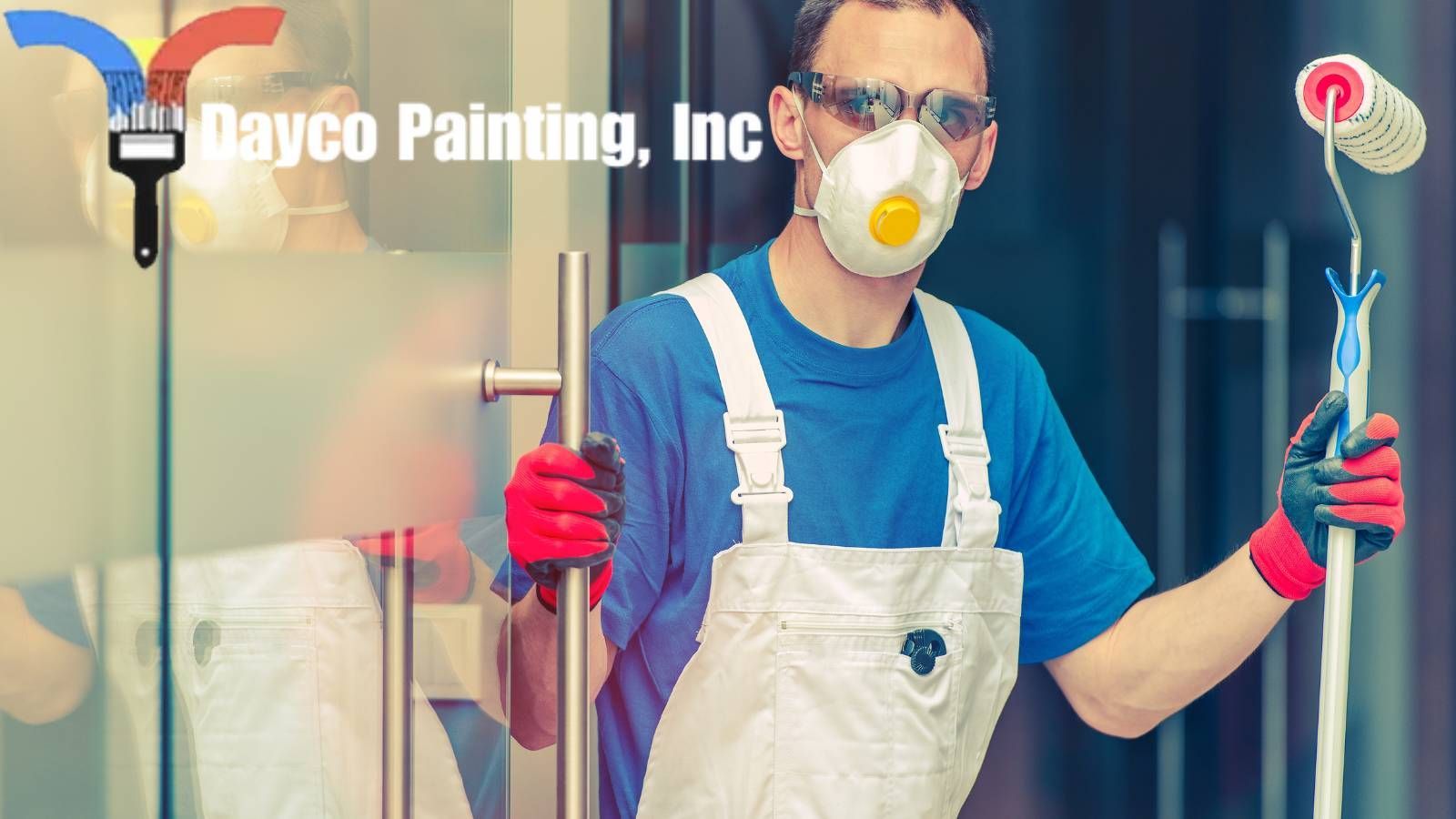 A hired professional painter wearing a mask is holding a paint roller.