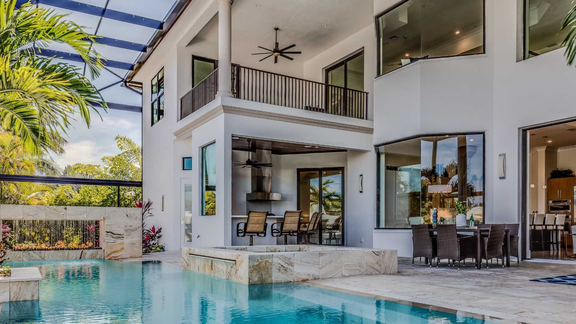 Luxury home exterior with pool and outdoor dining area.