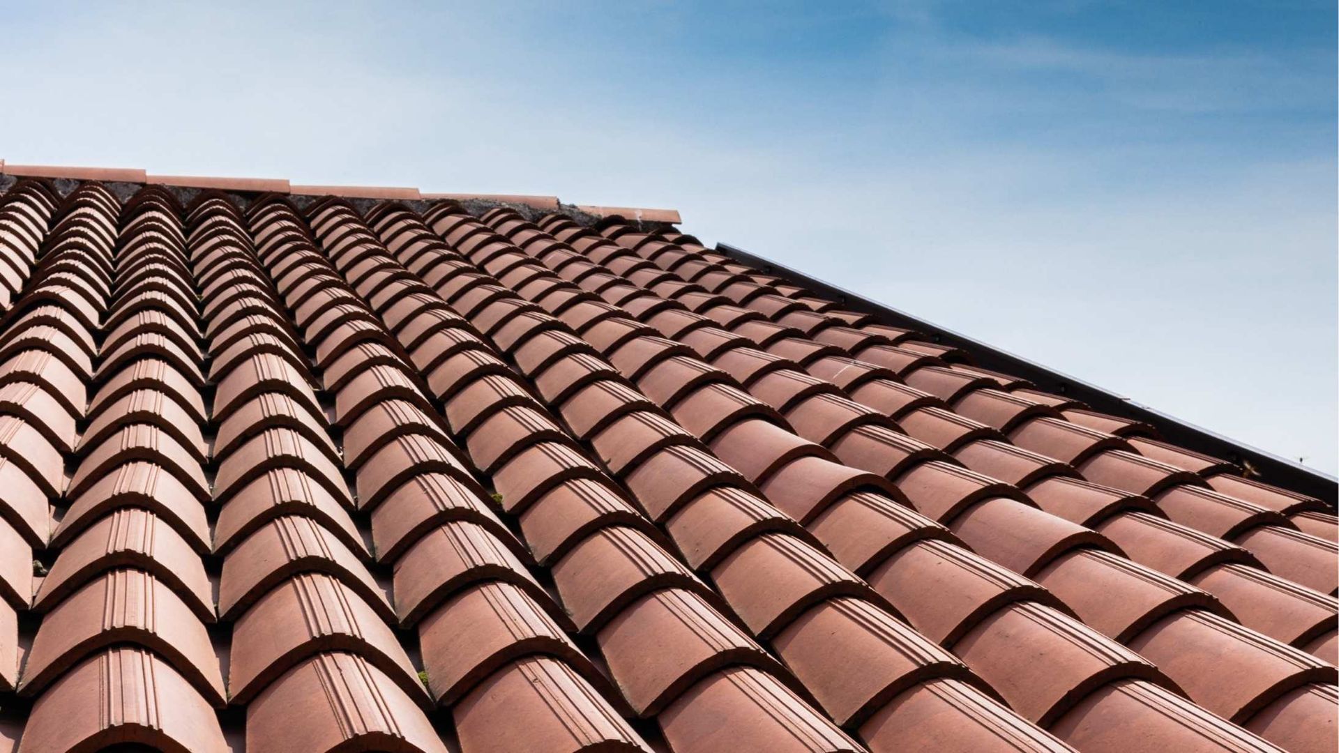 Red clay roof tiles against a blue sky.