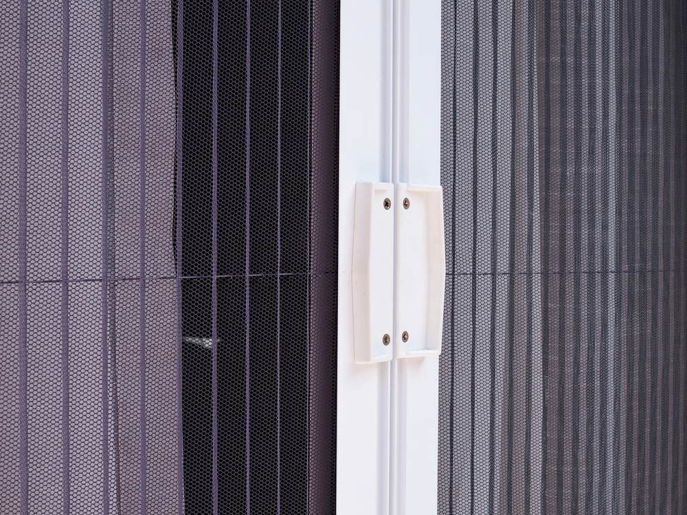 A Close Up Of A Pleated Screen Door With A White Handle — Ezi Slide - Glass, Sliding, Track & Security Doors Repair in Ashmore, QLD