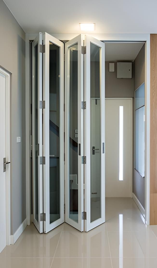 Hallway With a Staircase and a Folding Door — Ezi Slide - Glass, Sliding, Track & Security Doors Repair in Tweed Heads, NSW