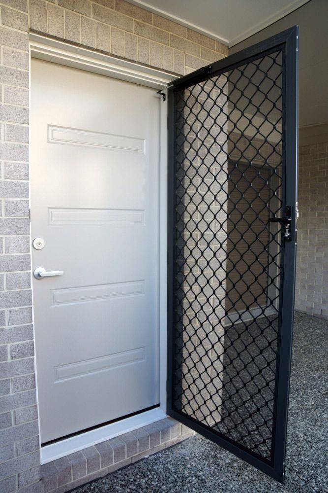 White Door With a Black Screen is Open to a Brick Wall — Ezi Slide - Glass, Sliding, Track & Security Doors Repair in Tweed Heads, NSW