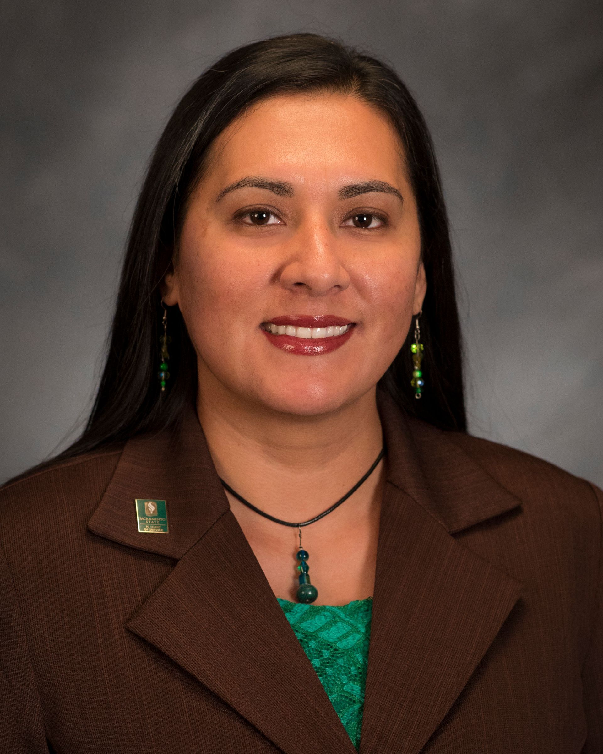 A woman wearing a brown jacket and a green shirt