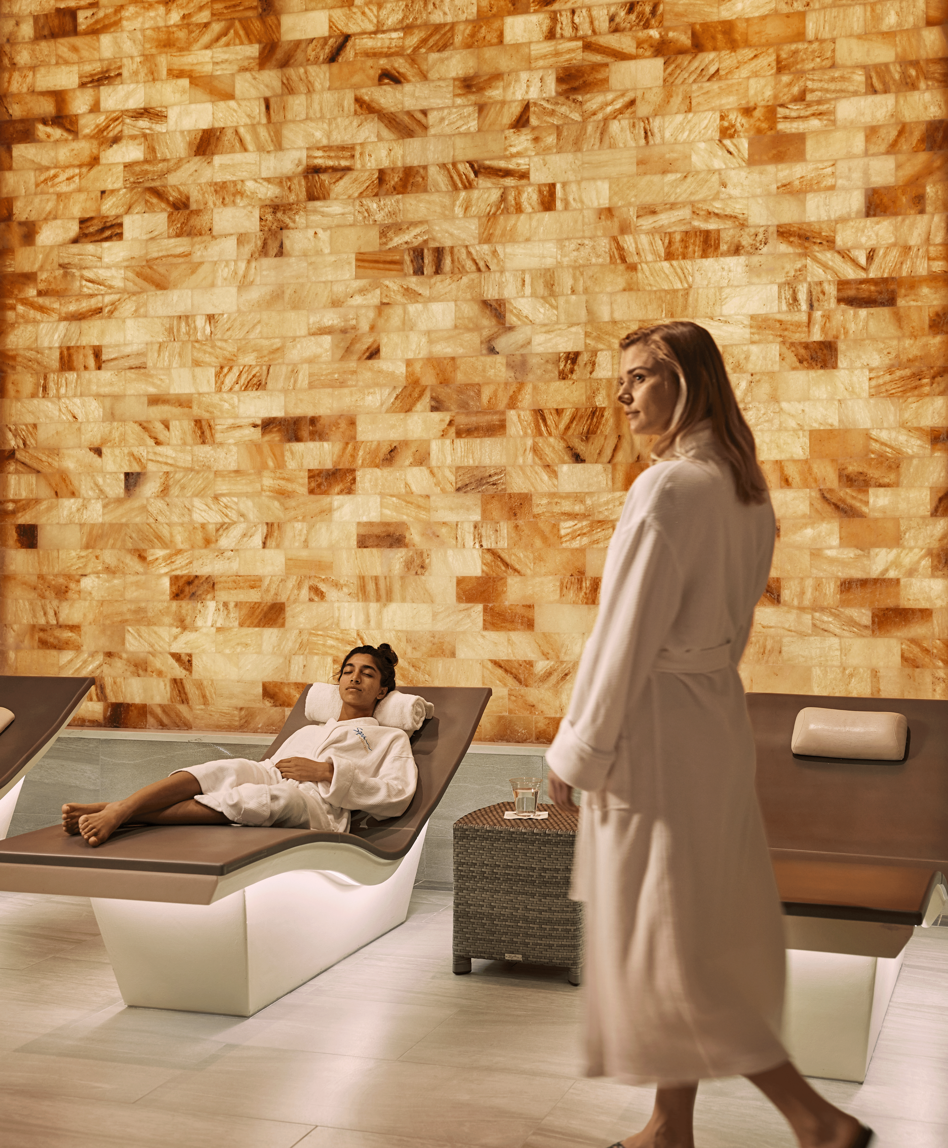 A woman wrapped in a towel is getting a facial treatment