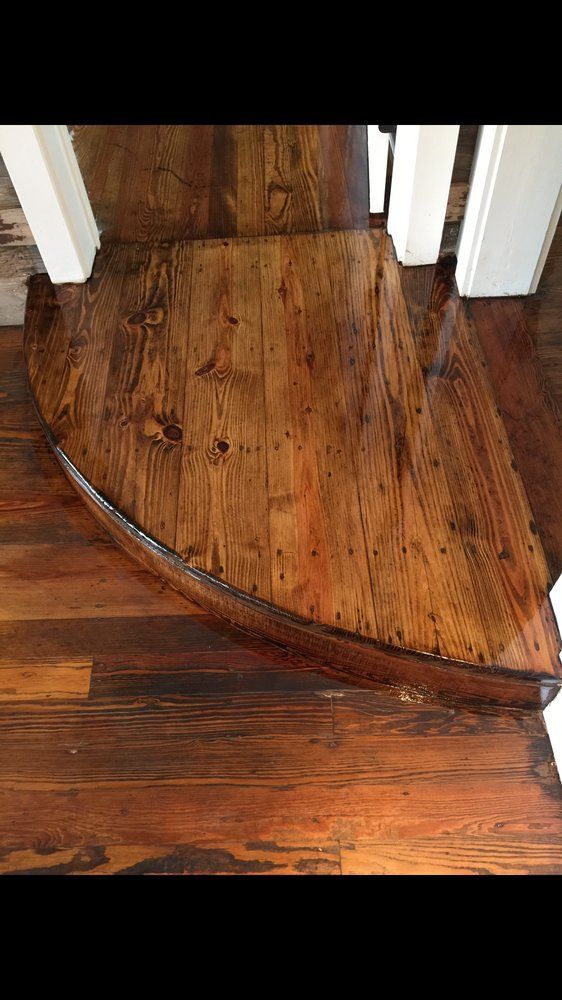 A close up of a wooden floor next to a staircase.
