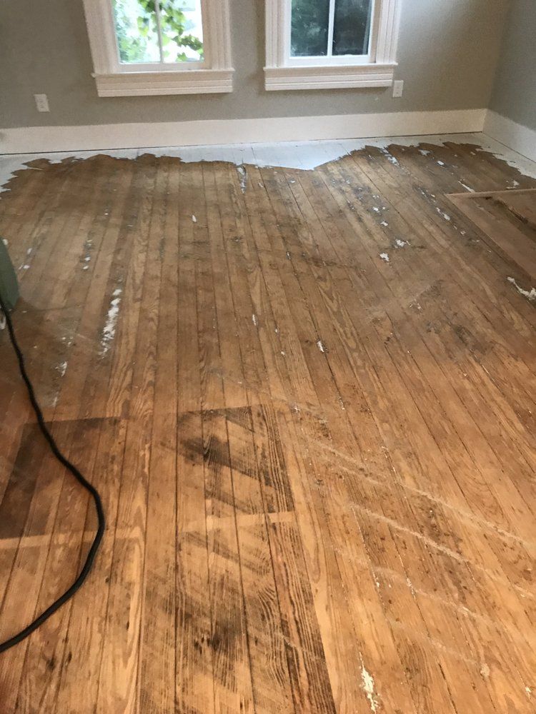 A wooden floor in a room with a window.
