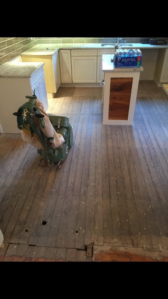 A machine is sitting on a wooden floor in a kitchen.