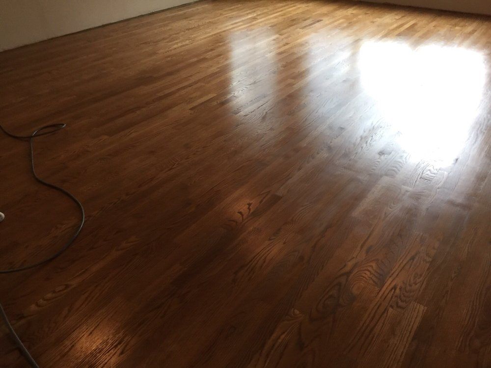 A living room with a wooden floor and a window.