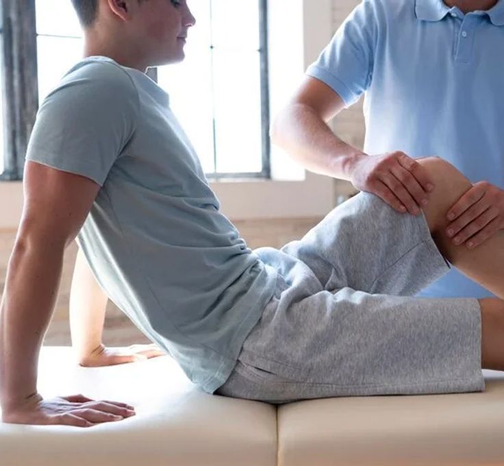 A man in a blue shirt is stretching his leg